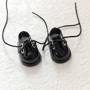 A pair of lace up black leather shoes